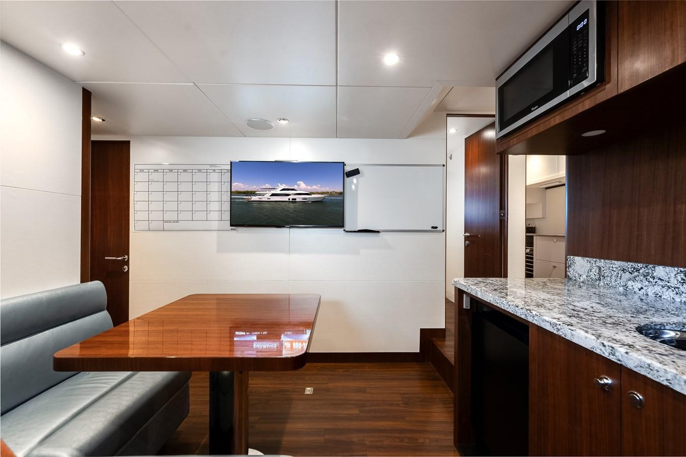 a kitchen with a table and a tv aboard WIGGLE ROOM Yacht for Sale