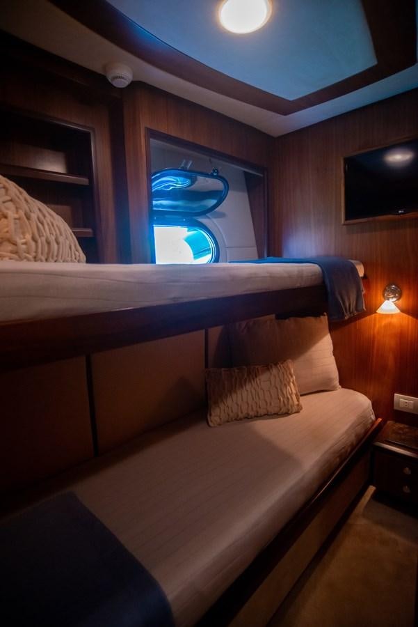 a bed with a blue pillow aboard TATI Yacht for Sale