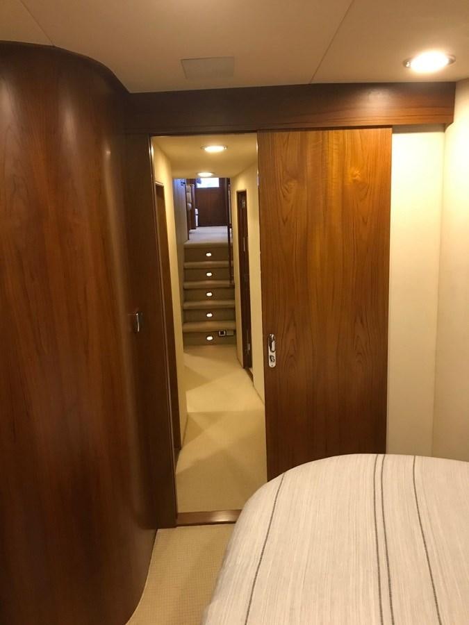 a hallway with a door and a chair aboard IN FLIGHT Yacht for Sale