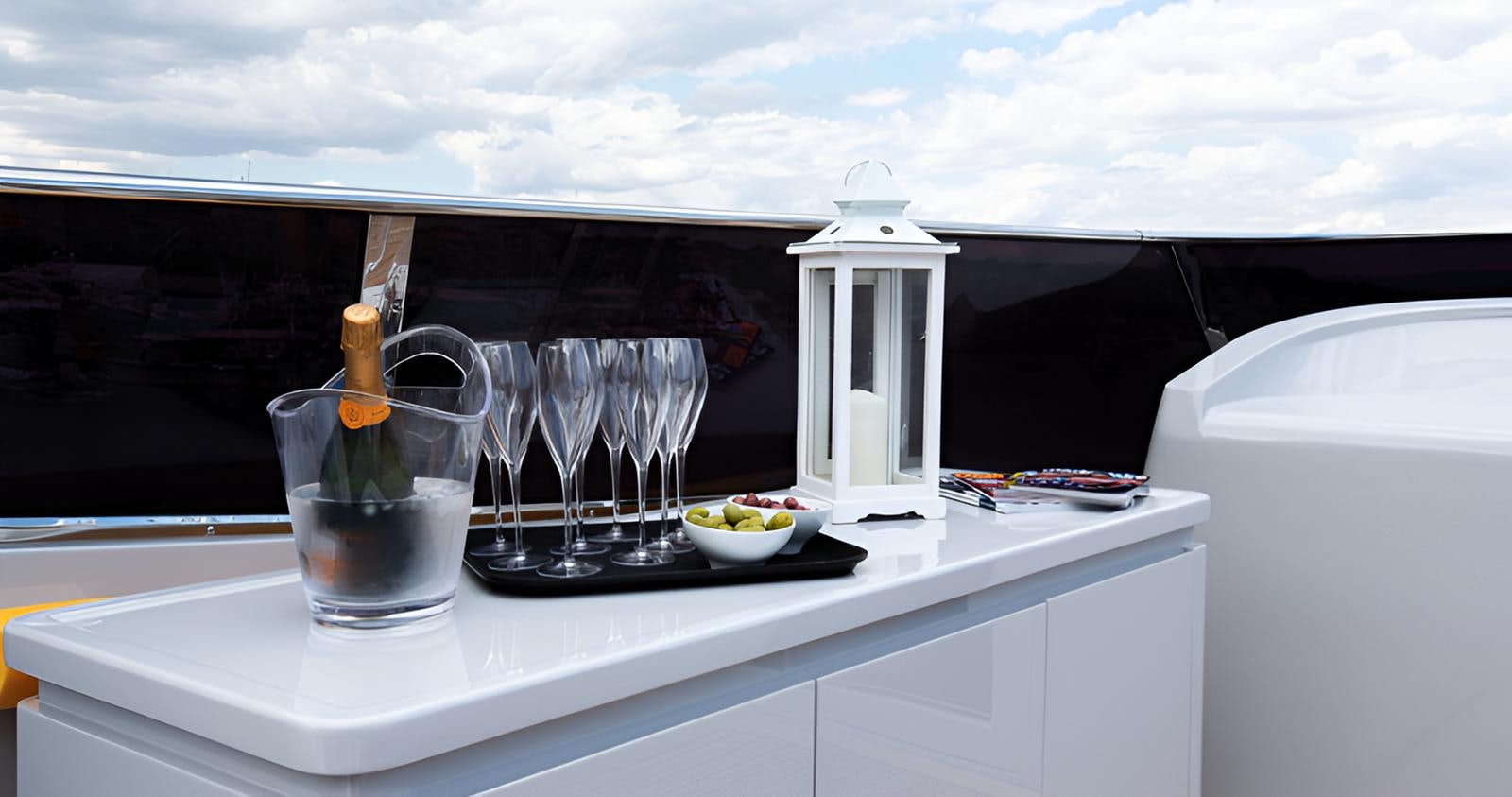 a glass bottle and a glass on a table aboard CAMILLA A Yacht for Sale