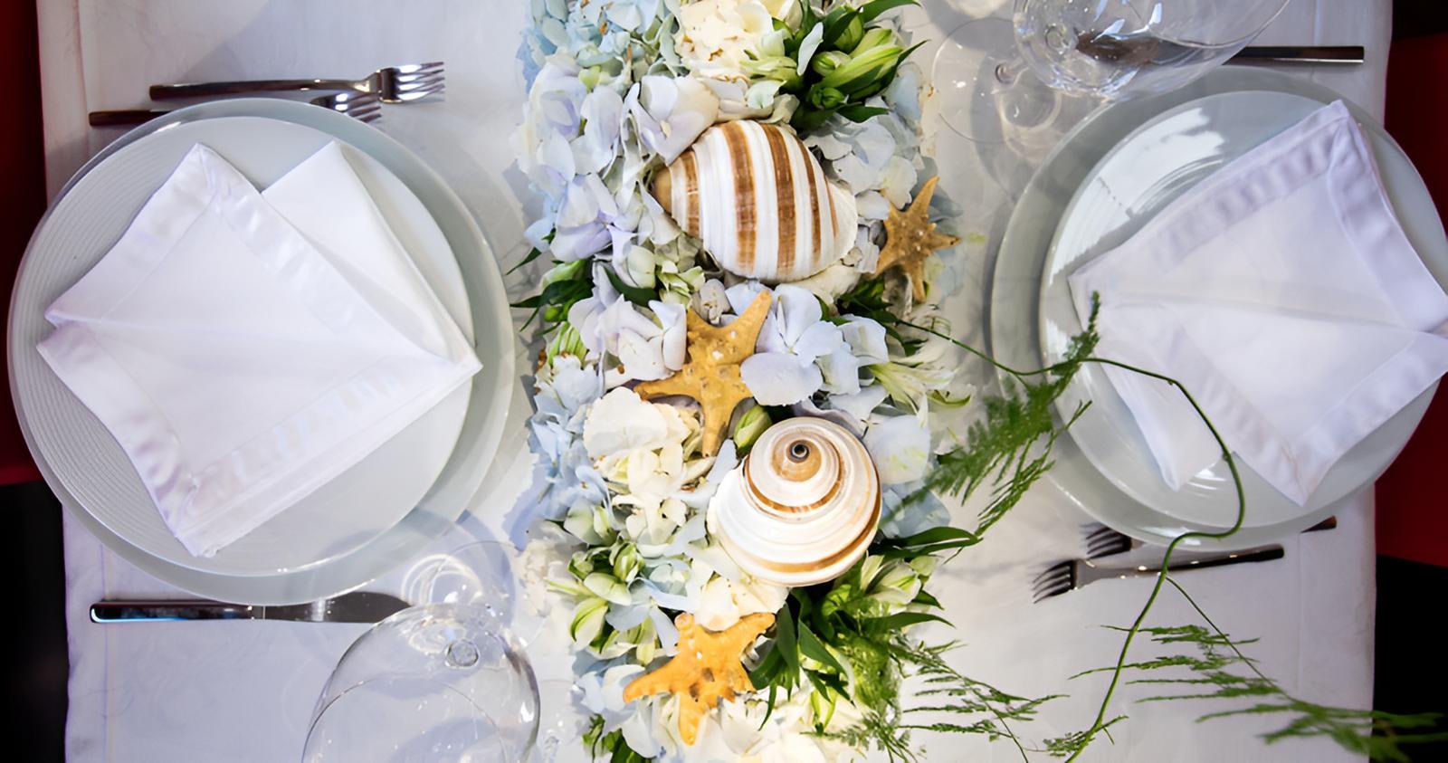 a table with flowers and plates aboard CAMILLA A Yacht for Sale