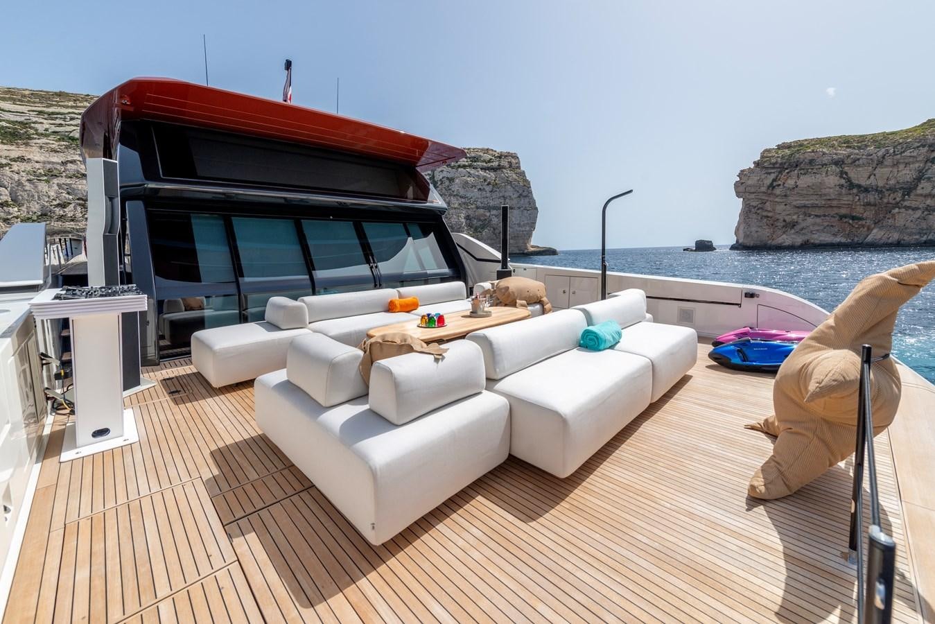 a white couch on a deck overlooking a body of water aboard HH Yacht for Sale