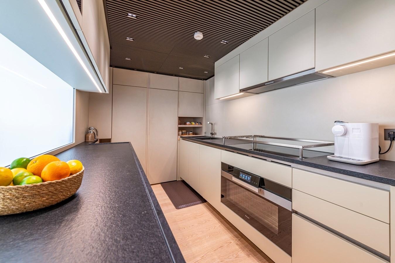 a kitchen with a basket of fruit aboard HH Yacht for Sale
