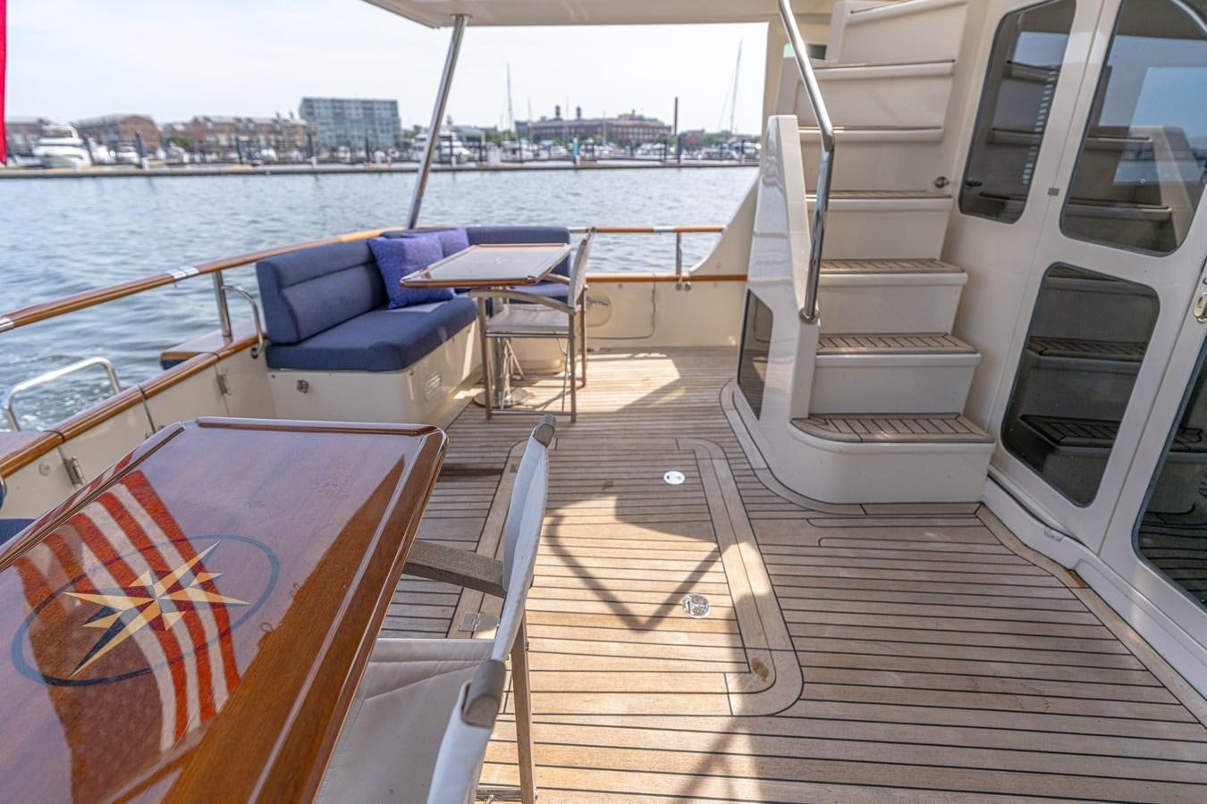 a deck with chairs and a table on it aboard UNDERDOG Yacht for Sale