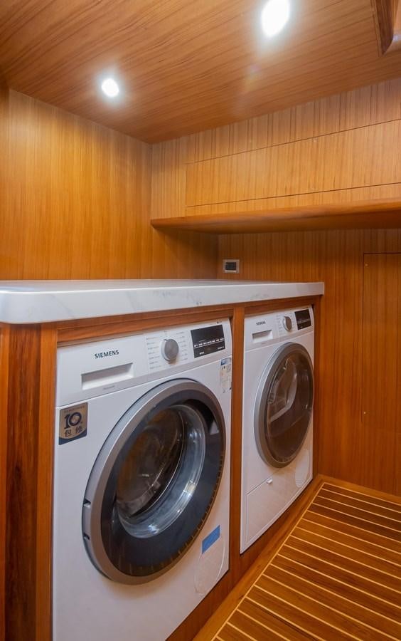 a washer and dryer in a wooden room aboard 2024 SELENE 62 Yacht for Sale