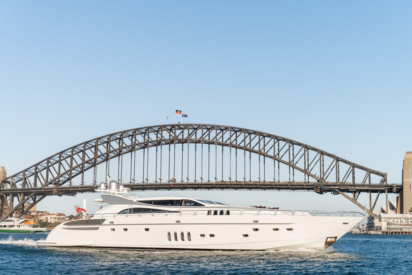 a large white boat in the water with Sydney Harbour Bridge in the background aboard YOLO Yacht for Sale