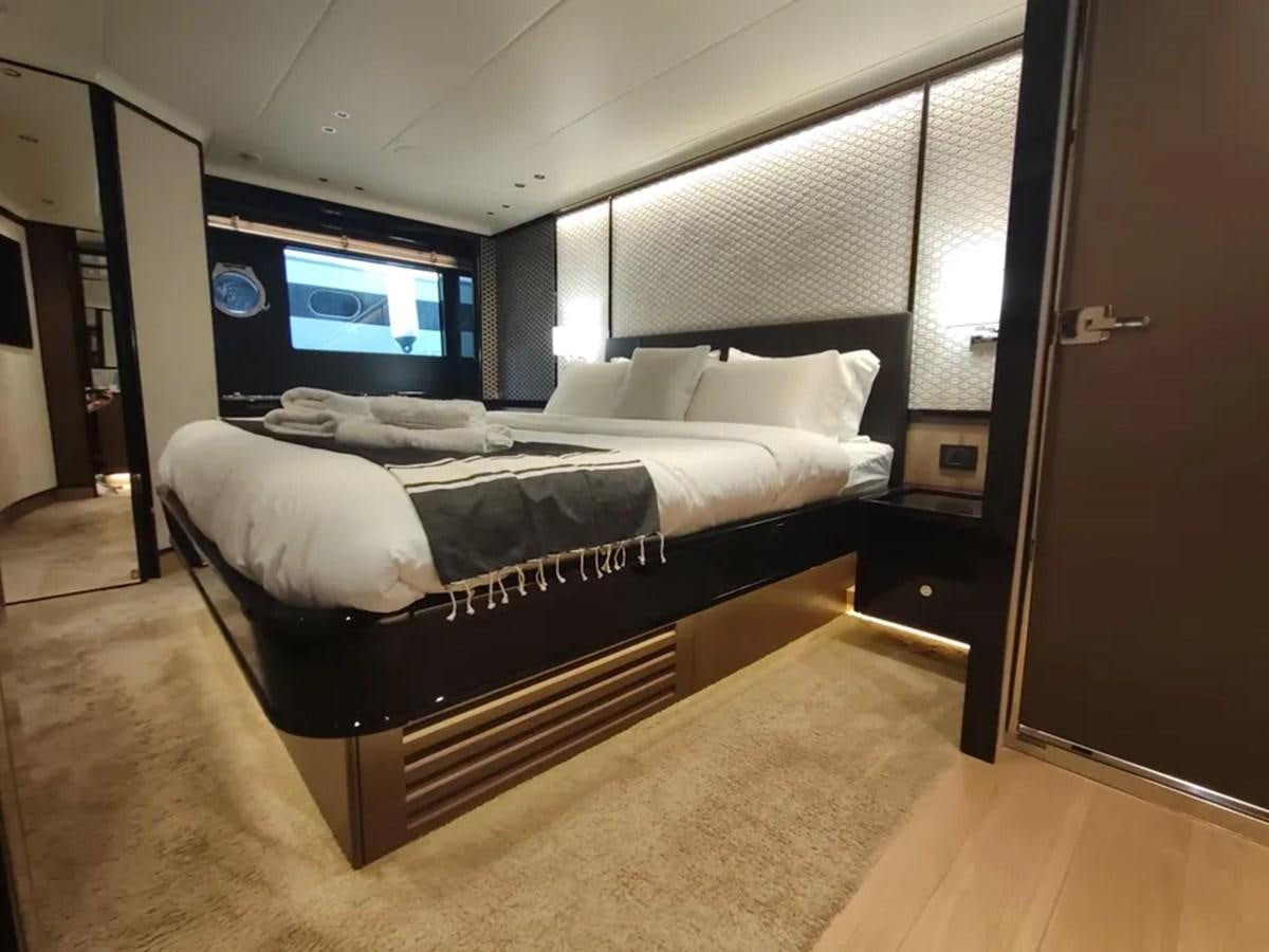a room with a bed and a tv on the wall aboard ELYSIUM Yacht for Sale