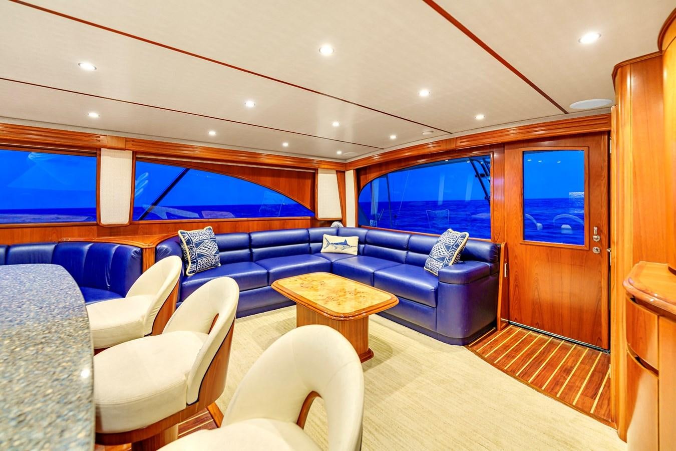 a living room with a blue couch and a wood table aboard LIFE IS GOOD Yacht for Sale