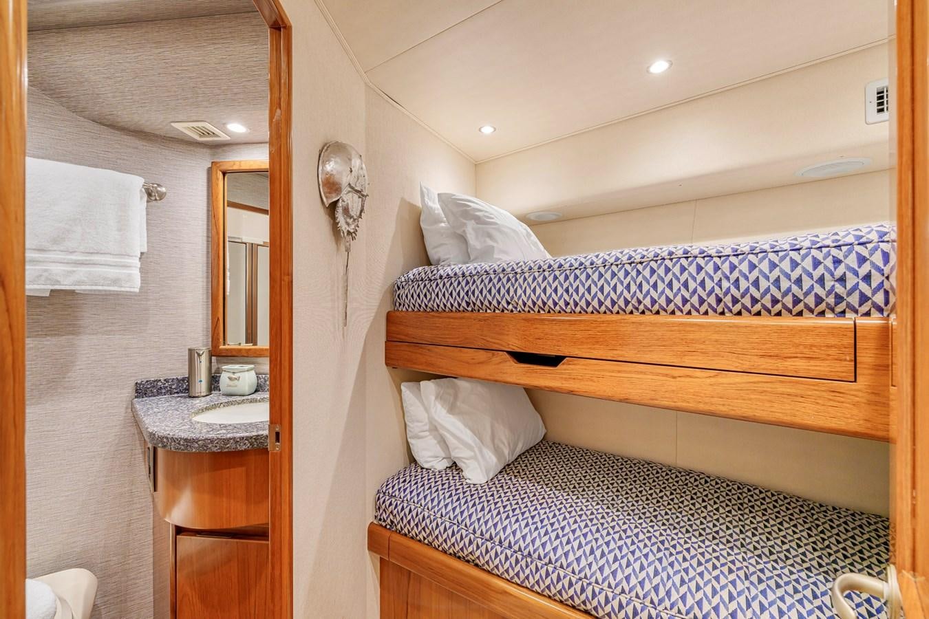 a bed with a blue and white comforter and a wooden headboard aboard LIFE IS GOOD Yacht for Sale