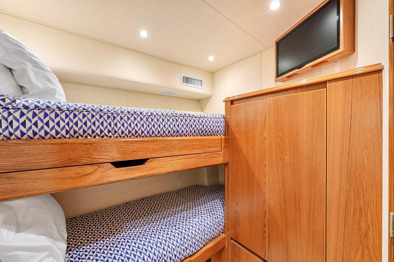a bed with a blue and white striped blanket aboard LIFE IS GOOD Yacht for Sale