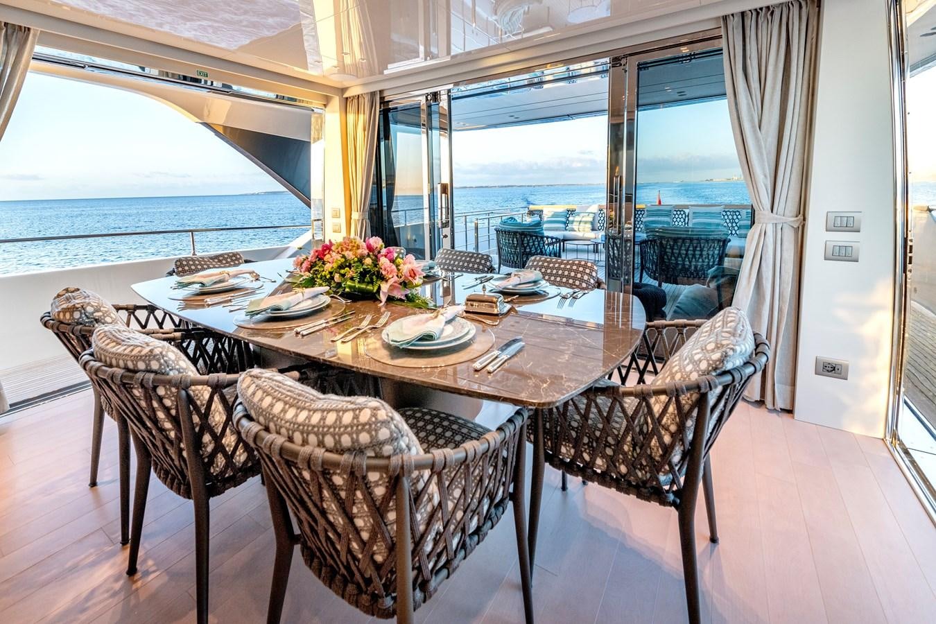 a dining table with chairs and a large window aboard SPERANZA II Yacht for Sale