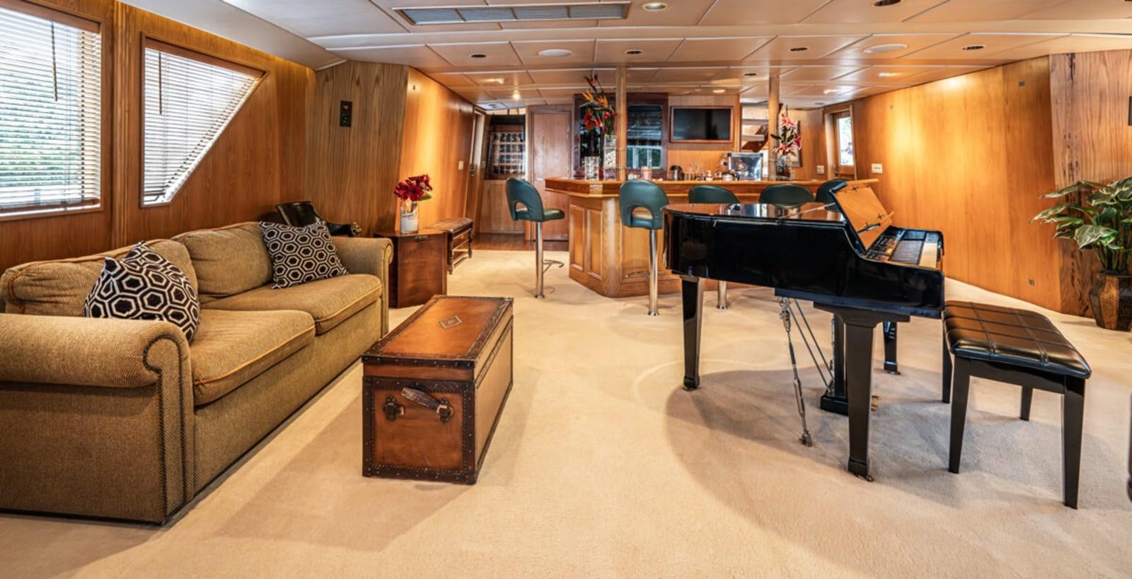 a living room with a couch and a piano aboard LE MONTRACHET Yacht for Sale
