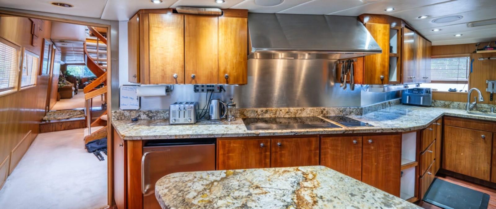 a kitchen with wooden cabinets aboard LE MONTRACHET Yacht for Sale