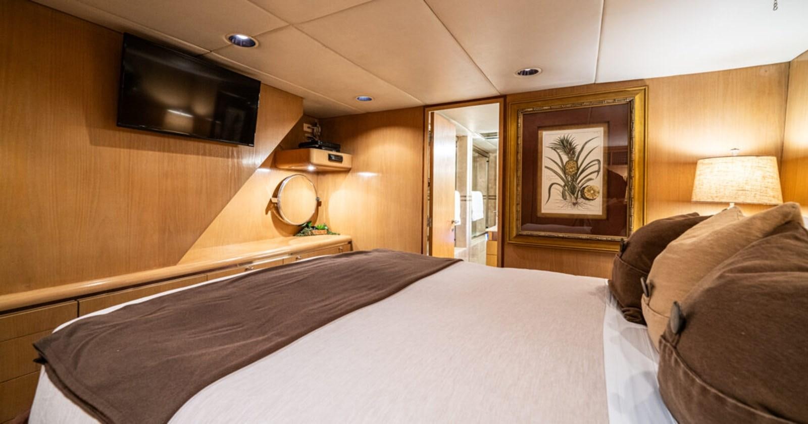 a room with a bed and a television aboard LE MONTRACHET Yacht for Sale