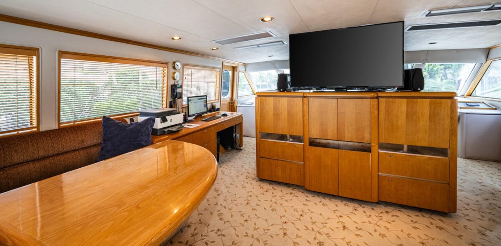 a room with a tv and a table aboard LE MONTRACHET Yacht for Sale