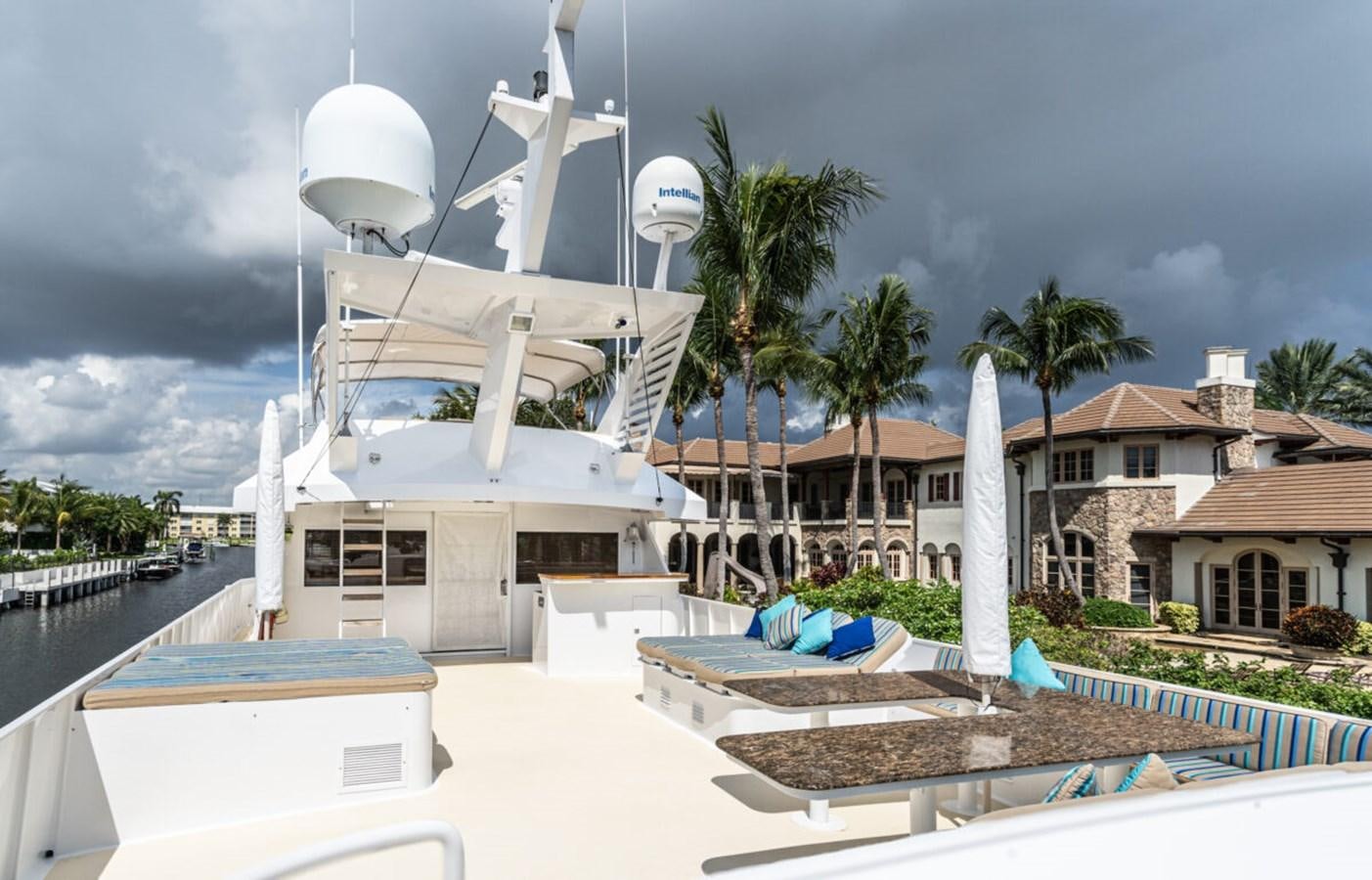 a white building with a dome and palm trees and a building with a cloudy sky aboard LE MONTRACHET Yacht for Sale