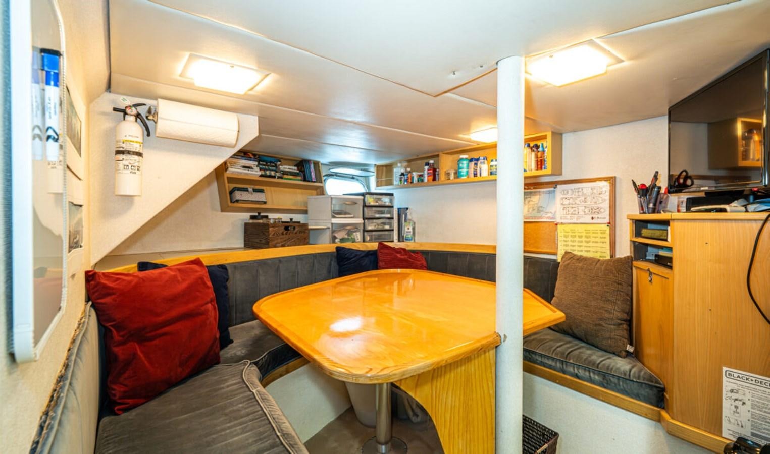 a room with a table and couch aboard LE MONTRACHET Yacht for Sale