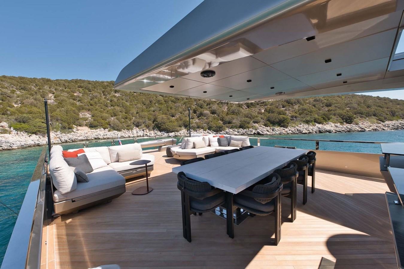 a deck with a pool and a table and chairs on it aboard ROCK X Yacht for Sale