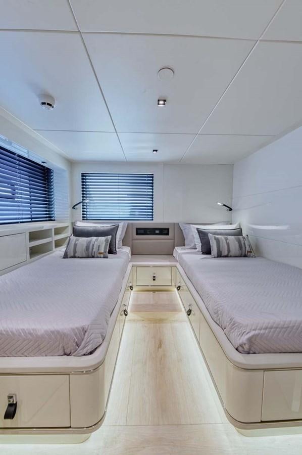 a room with white beds aboard ROCK X Yacht for Sale