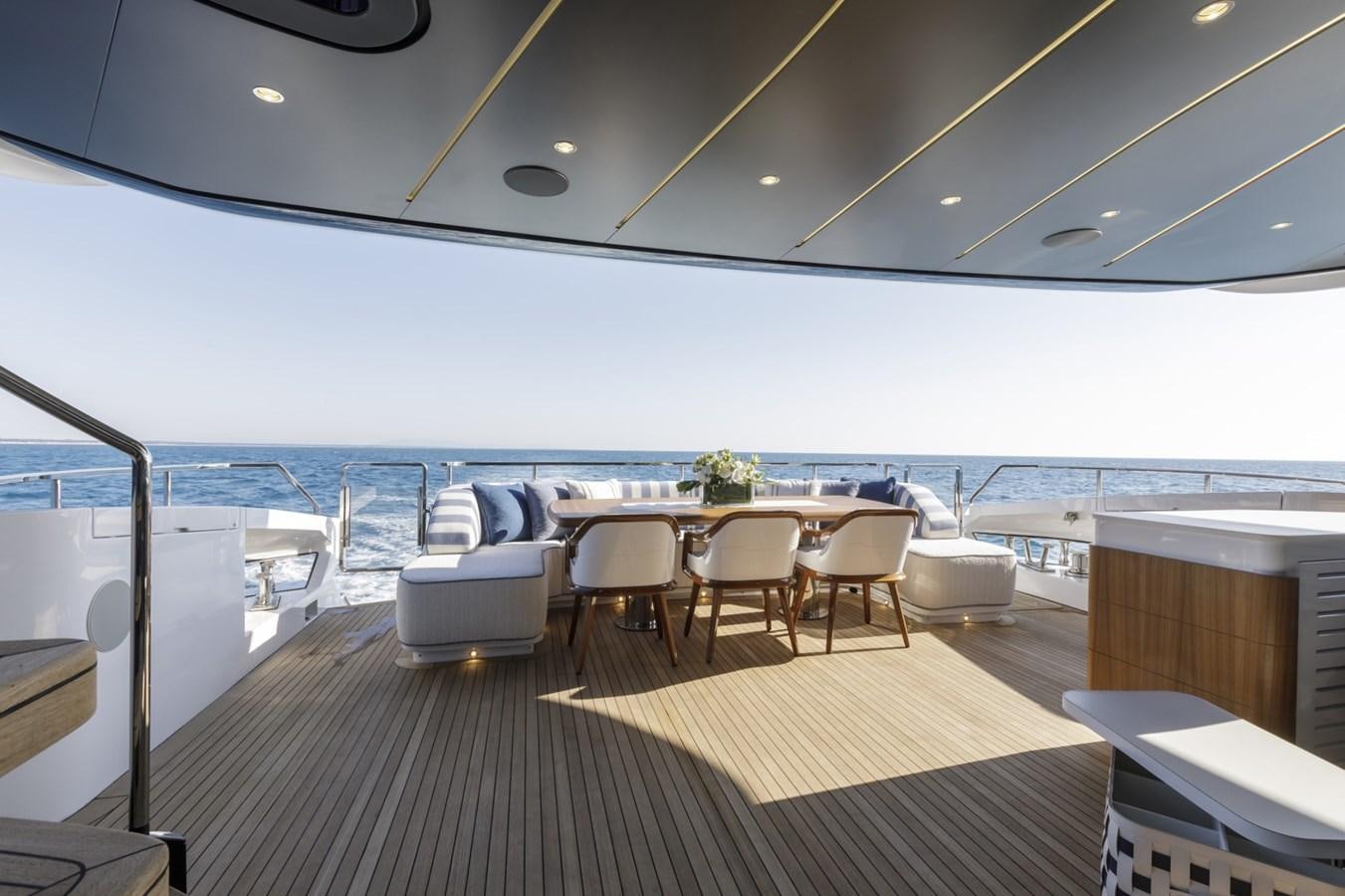a deck with a table and chairs on it aboard MYSTERE Yacht for Sale