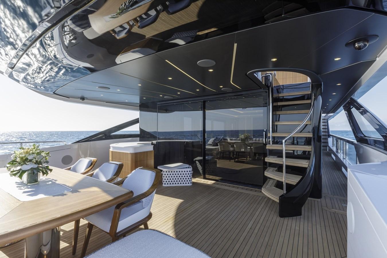 a room with a large glass window and a table with chairs and a view of the ocean aboard MYSTERE Yacht for Sale