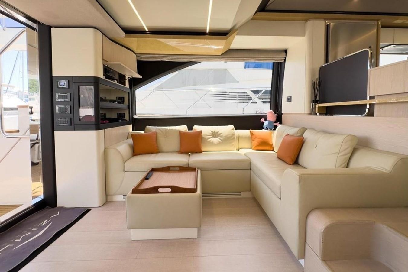 a living room with a couch and a coffee table aboard AZIMUT 66 FLY Yacht for Sale