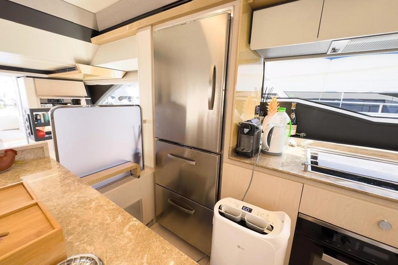 a kitchen with a stainless steel refrigerator aboard AZIMUT 66 FLY Yacht for Sale