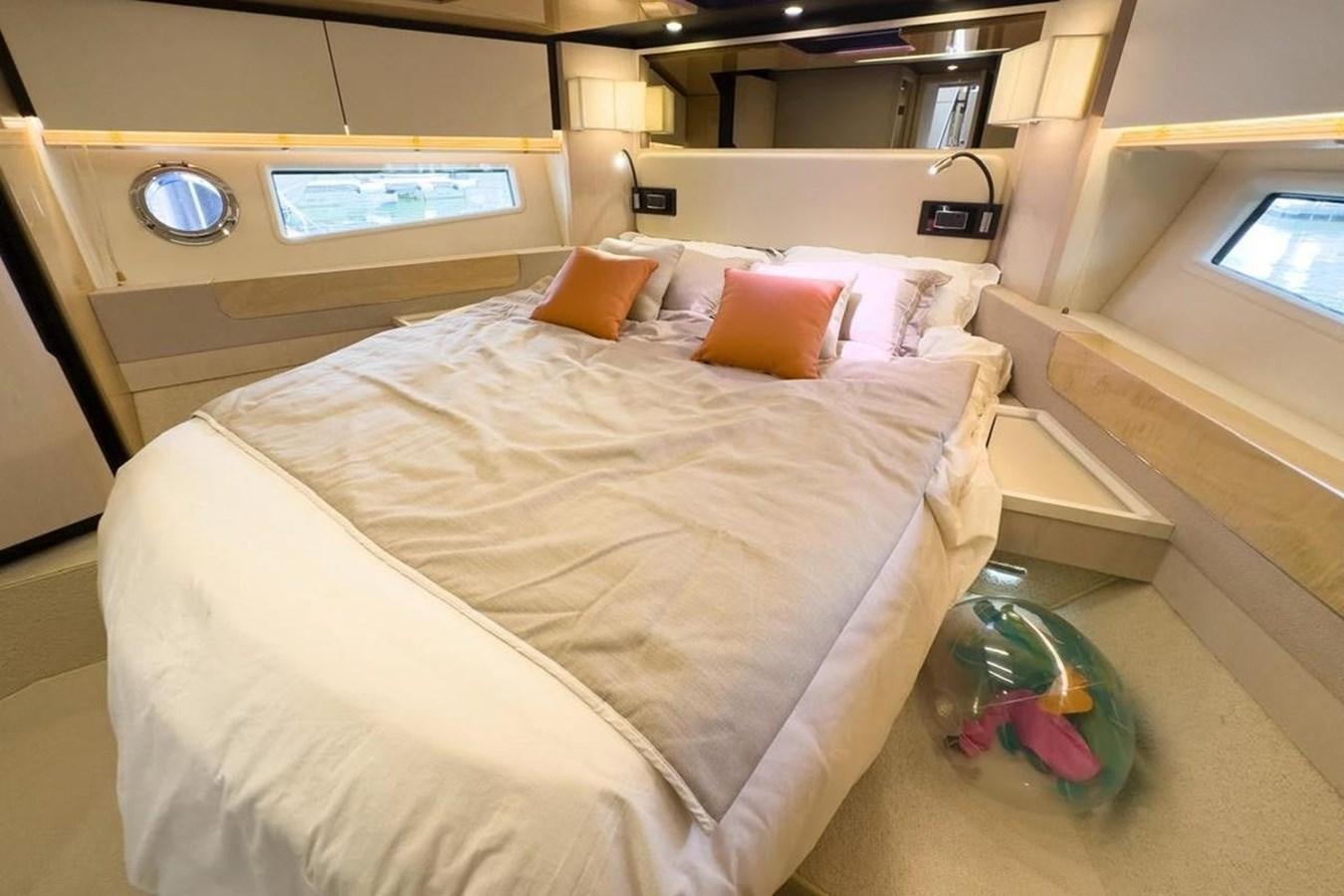 a bed with a white sheet and orange pillows aboard AZIMUT 66 FLY Yacht for Sale
