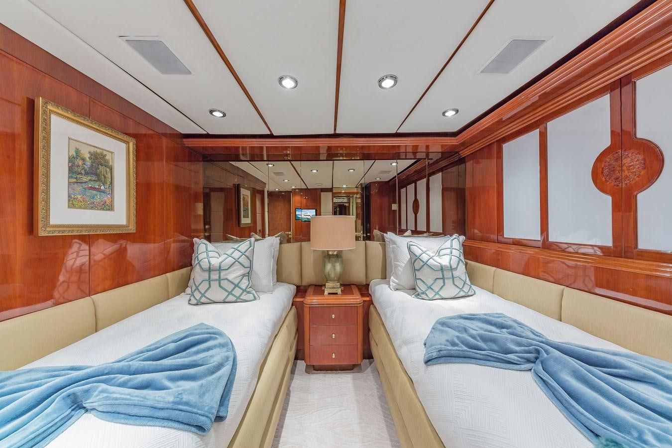a room with beds and a lamp aboard QUINTESSA Yacht for Sale