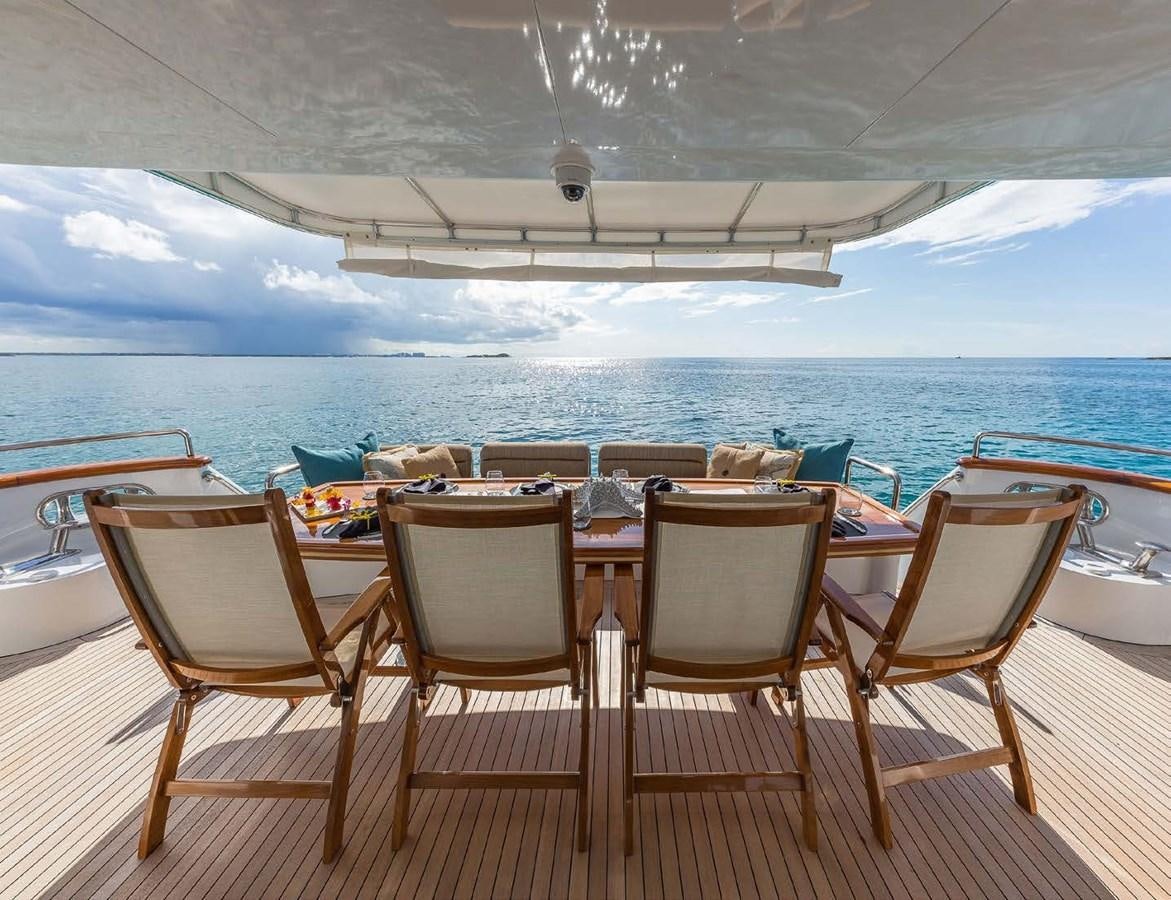 a table and chairs on a deck overlooking a large body of water aboard QUINTESSA Yacht for Sale