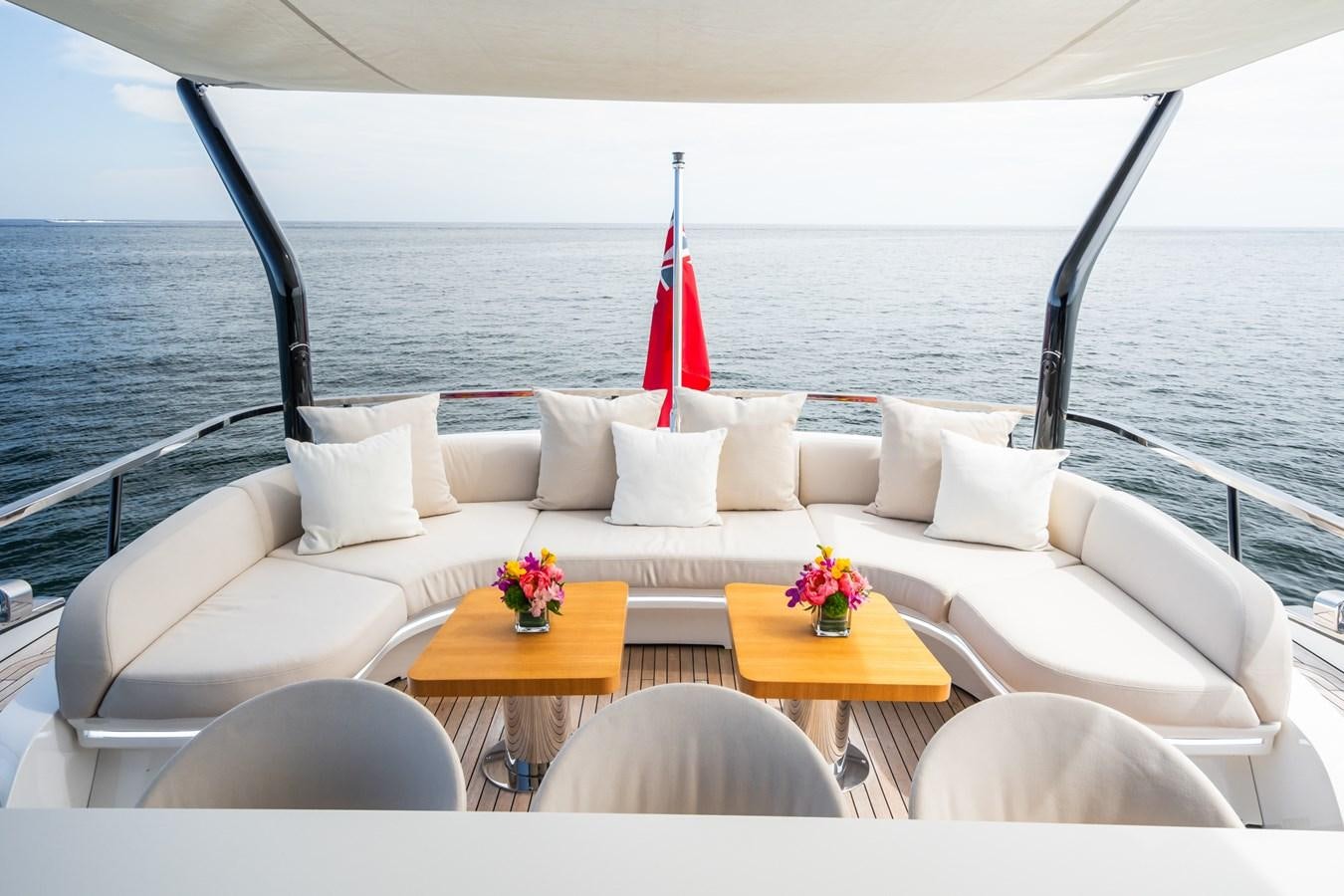 a white couch with a table and chairs on it aboard JACQPOT Yacht for Sale