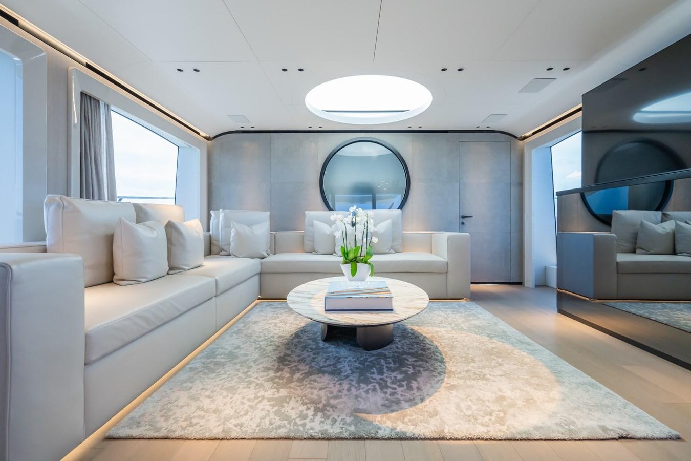 a living room with a round table aboard JACQPOT Yacht for Sale