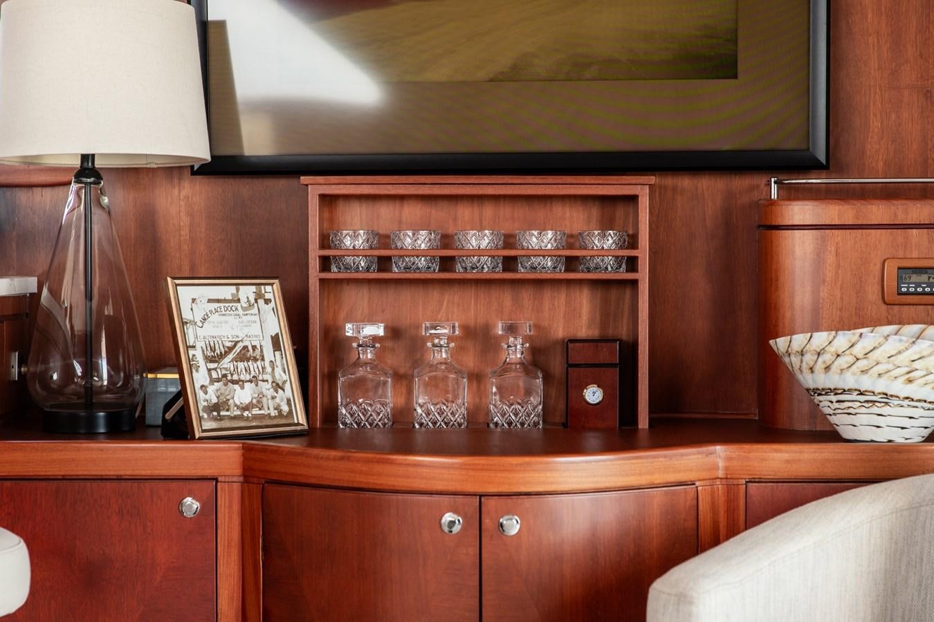 a wooden cabinet with glasses on it aboard ARAGOSTA Yacht for Sale