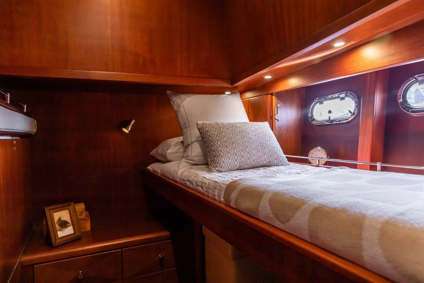 a bed with a white pillow aboard ARAGOSTA Yacht for Sale