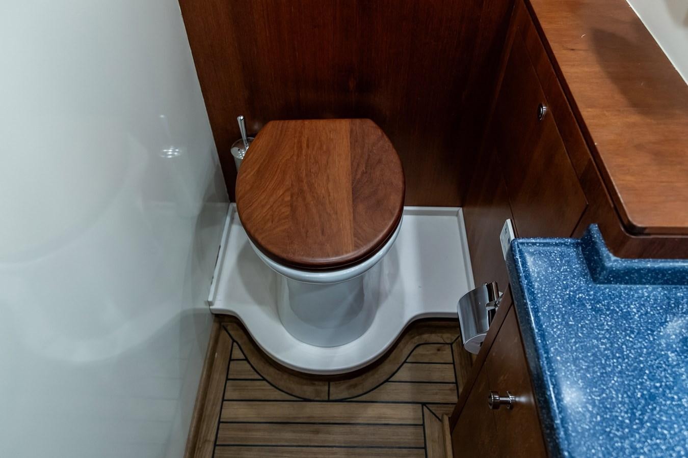 a toilet with a wooden seat aboard ARAGOSTA Yacht for Sale