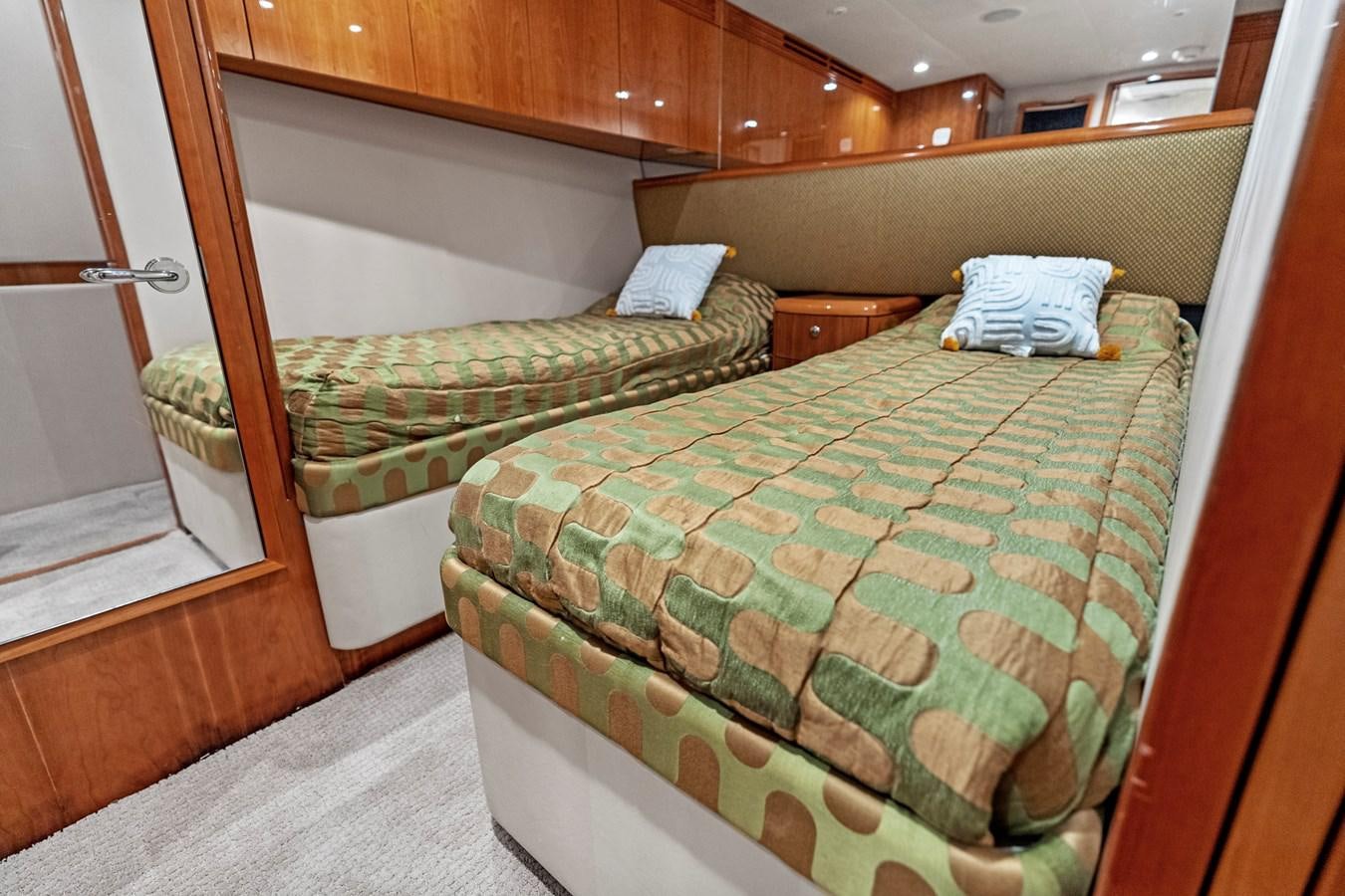 a bed with a green blanket aboard NAUTICAL NOMAD Yacht for Sale