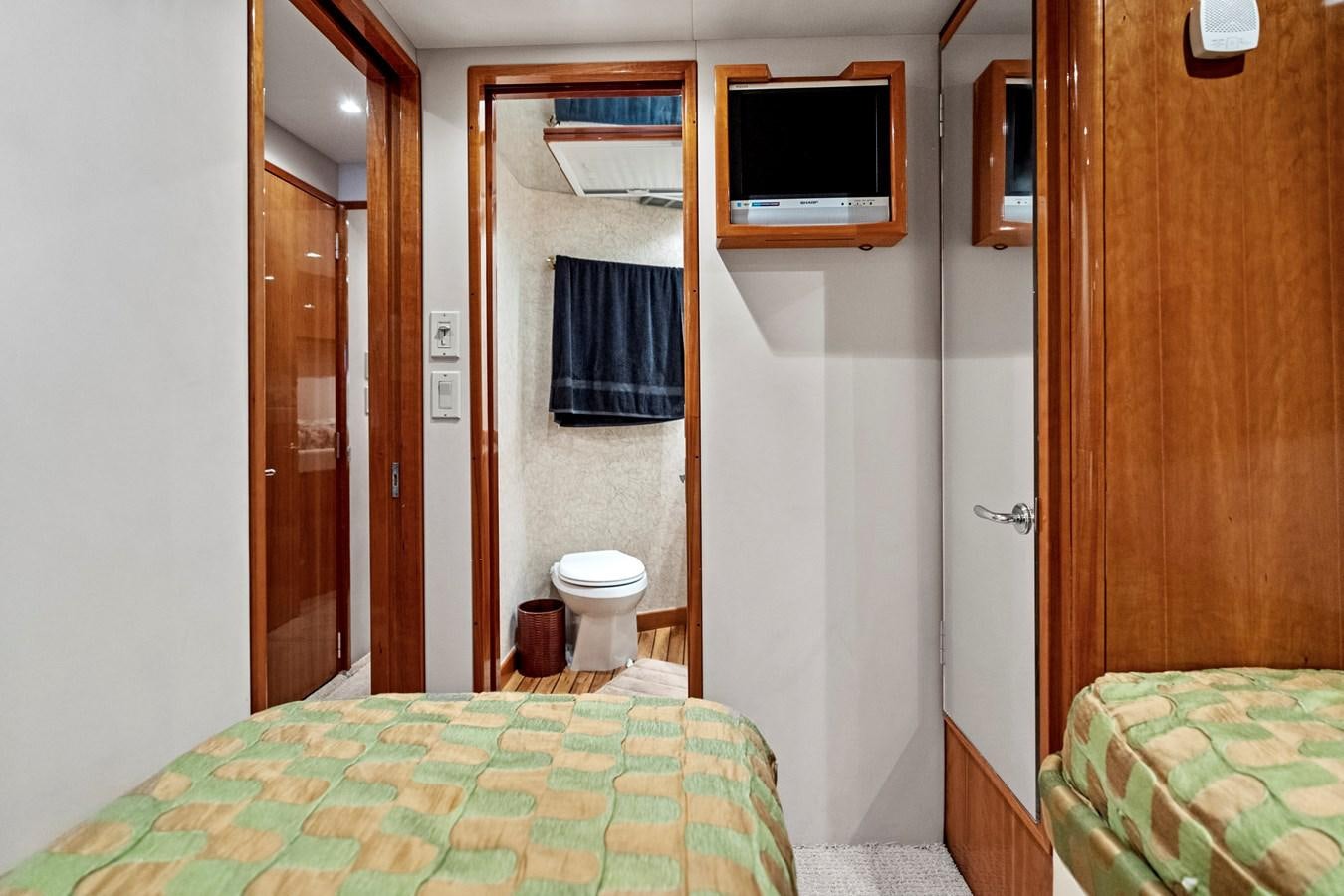 a bedroom with a bed and a television on the wall aboard NAUTICAL NOMAD Yacht for Sale