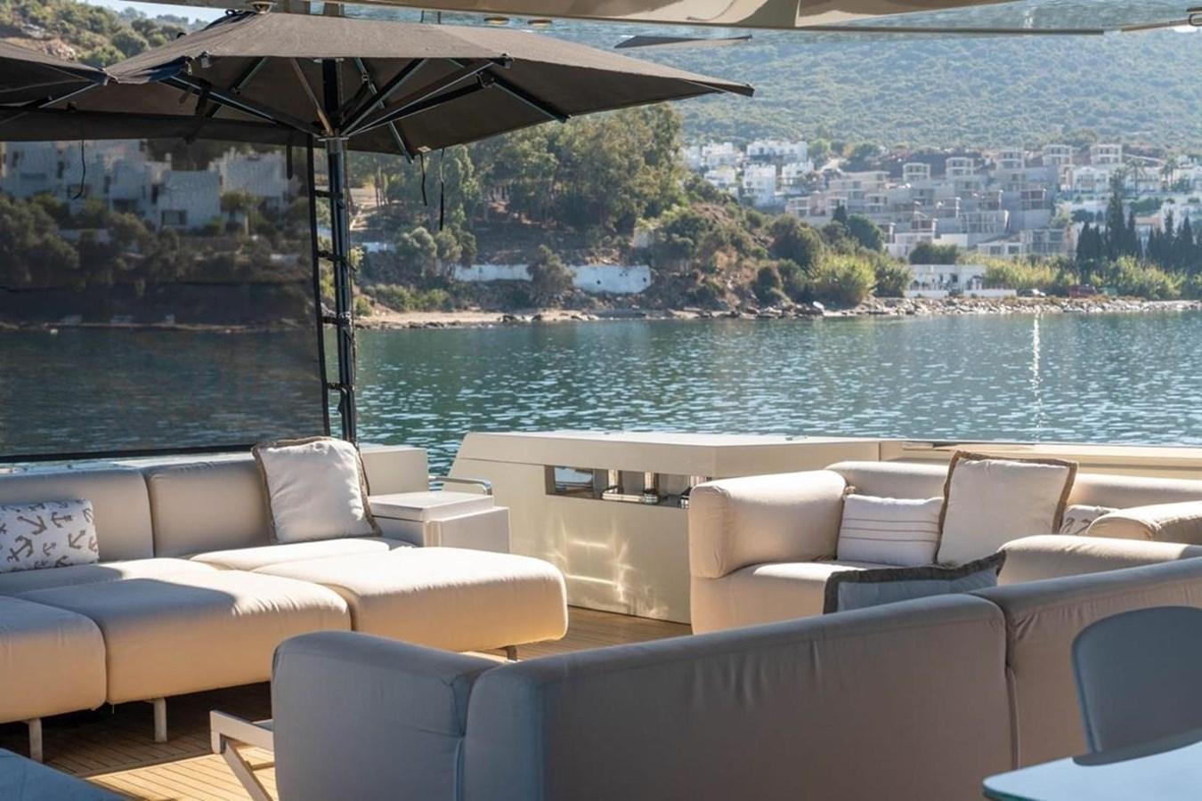 a lounge area with a large body of water and a city in the background aboard ARCADIA 85 2015 Yacht for Sale