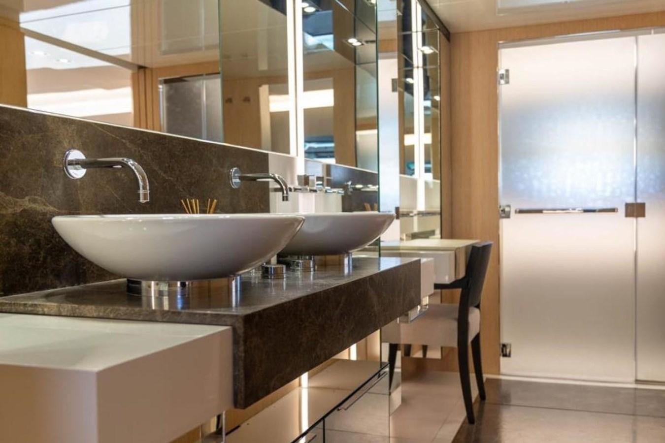 a modern bathroom with a sink and a large mirror aboard ARCADIA 85 2015 Yacht for Sale