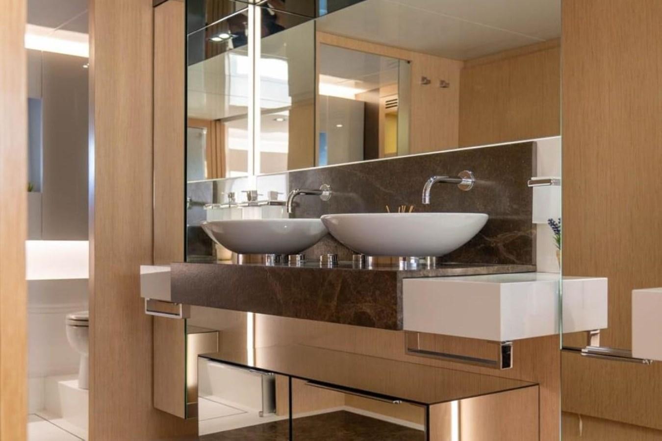 a bathroom with a sink and a mirror aboard ARCADIA 85 2015 Yacht for Sale