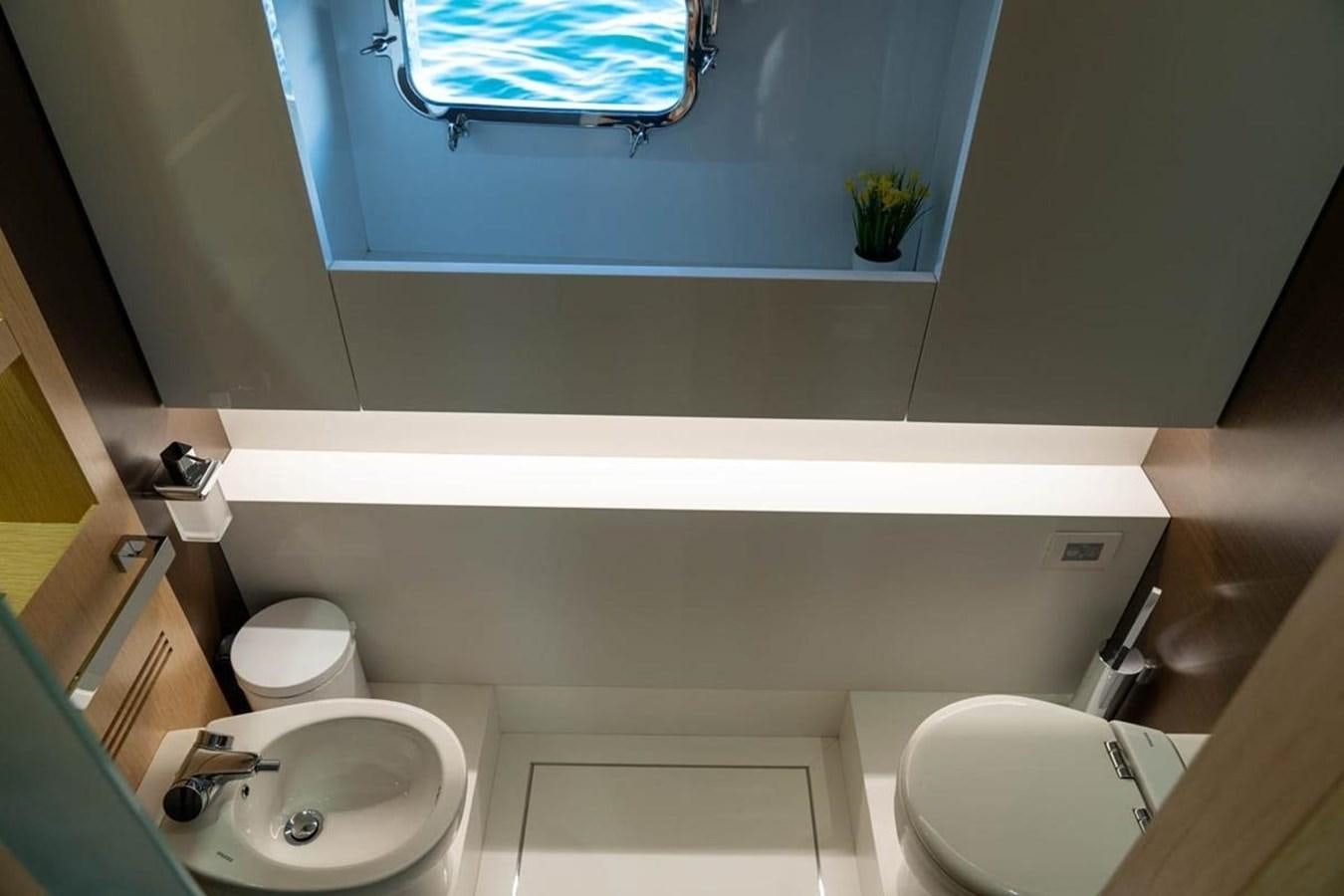 a bathroom with a sink toilet and a window aboard ARCADIA 85 2015 Yacht for Sale