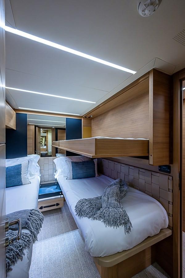 a bedroom with a bed and a wood cabinet aboard COAL BLOODED Yacht for Sale