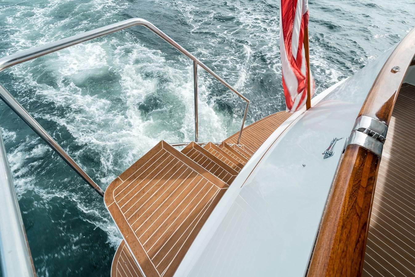 a boat with a flag on the front aboard HIGH IMPACT Yacht for Sale