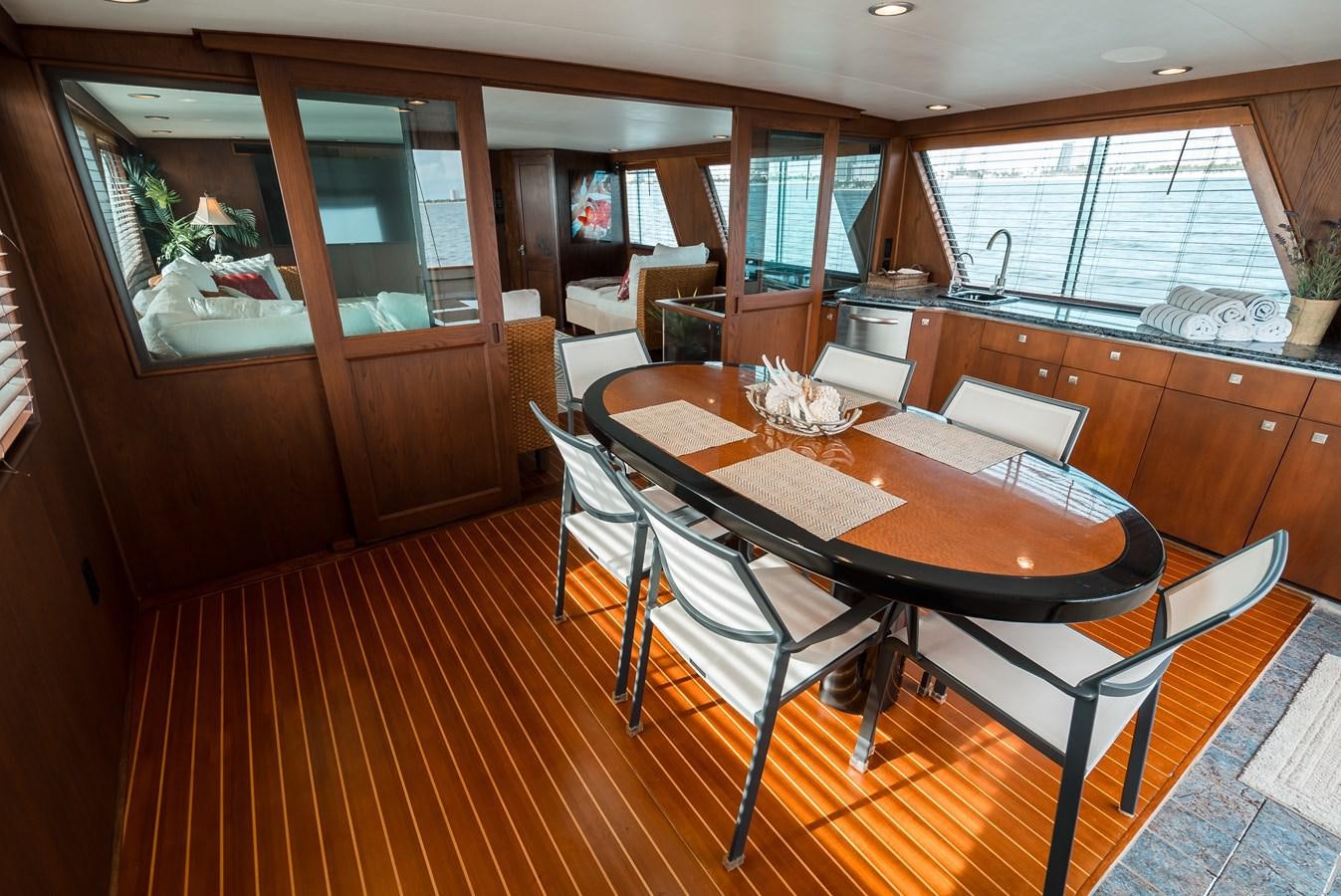 a dining table and chairs in a room with a wood floor aboard HIGH IMPACT Yacht for Sale