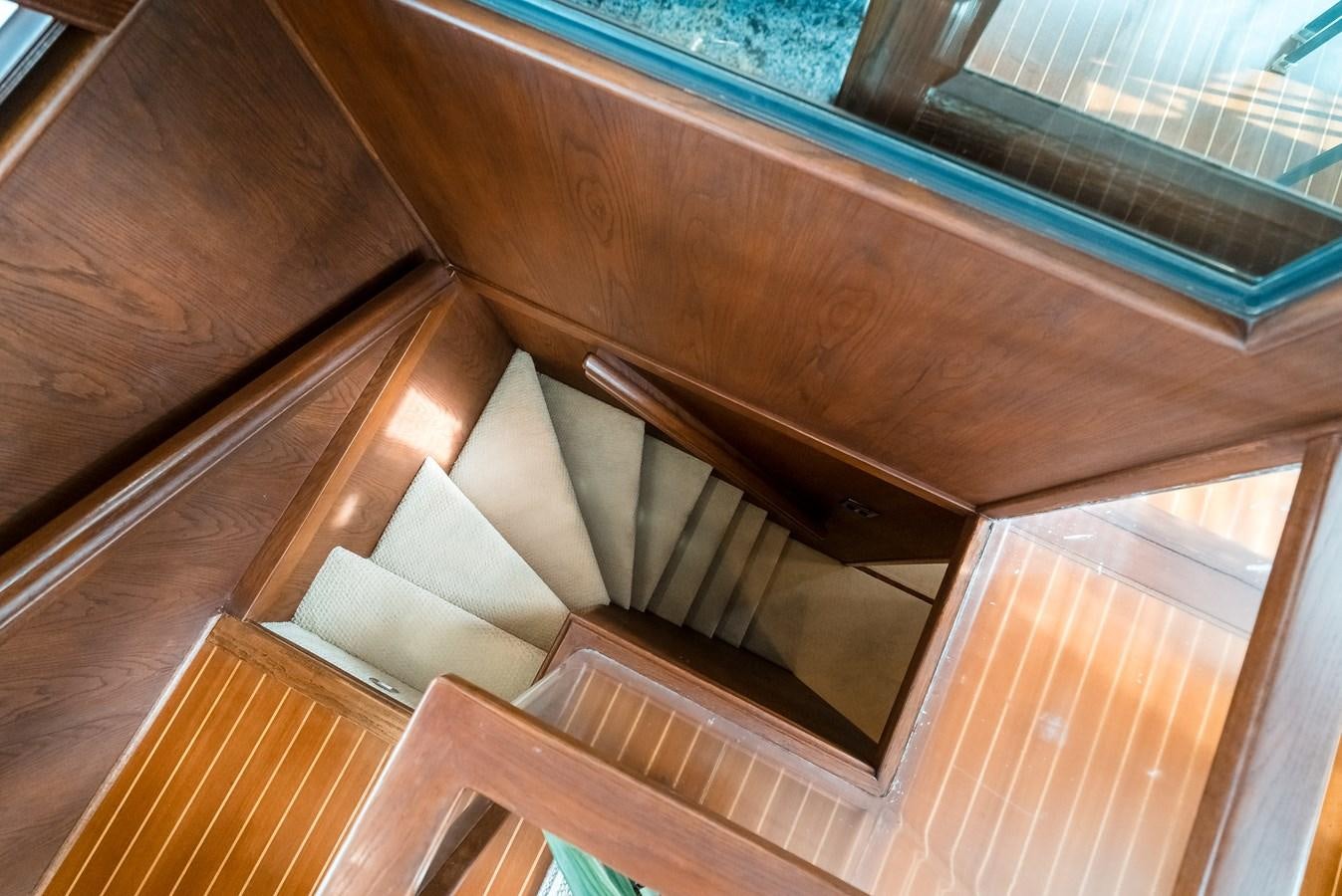 a wooden staircase with a glass window aboard HIGH IMPACT Yacht for Sale