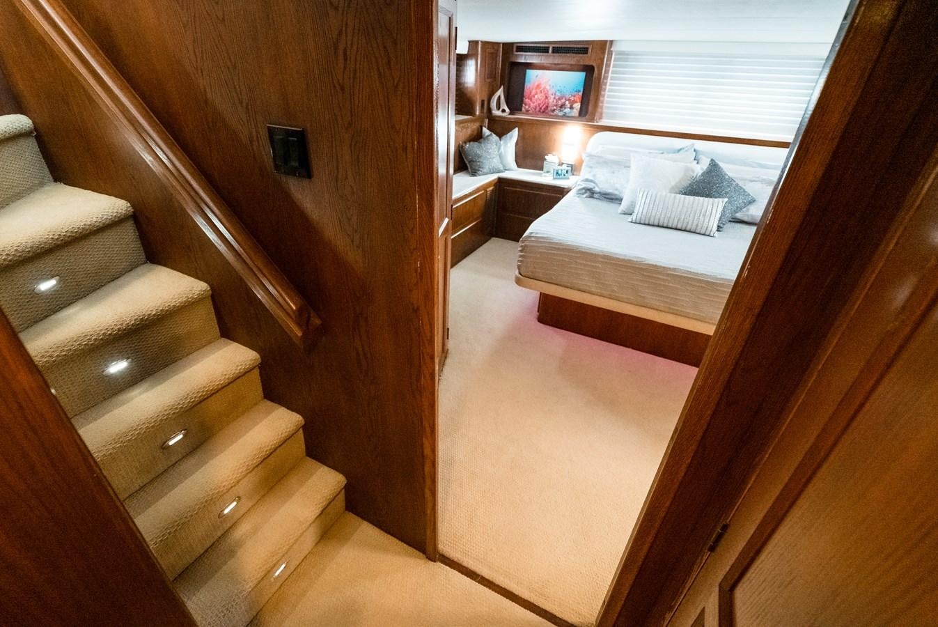 a room with a bed and a wood door aboard HIGH IMPACT Yacht for Sale