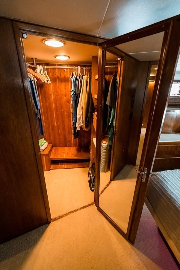 a closet with clothes on the wall aboard HIGH IMPACT Yacht for Sale