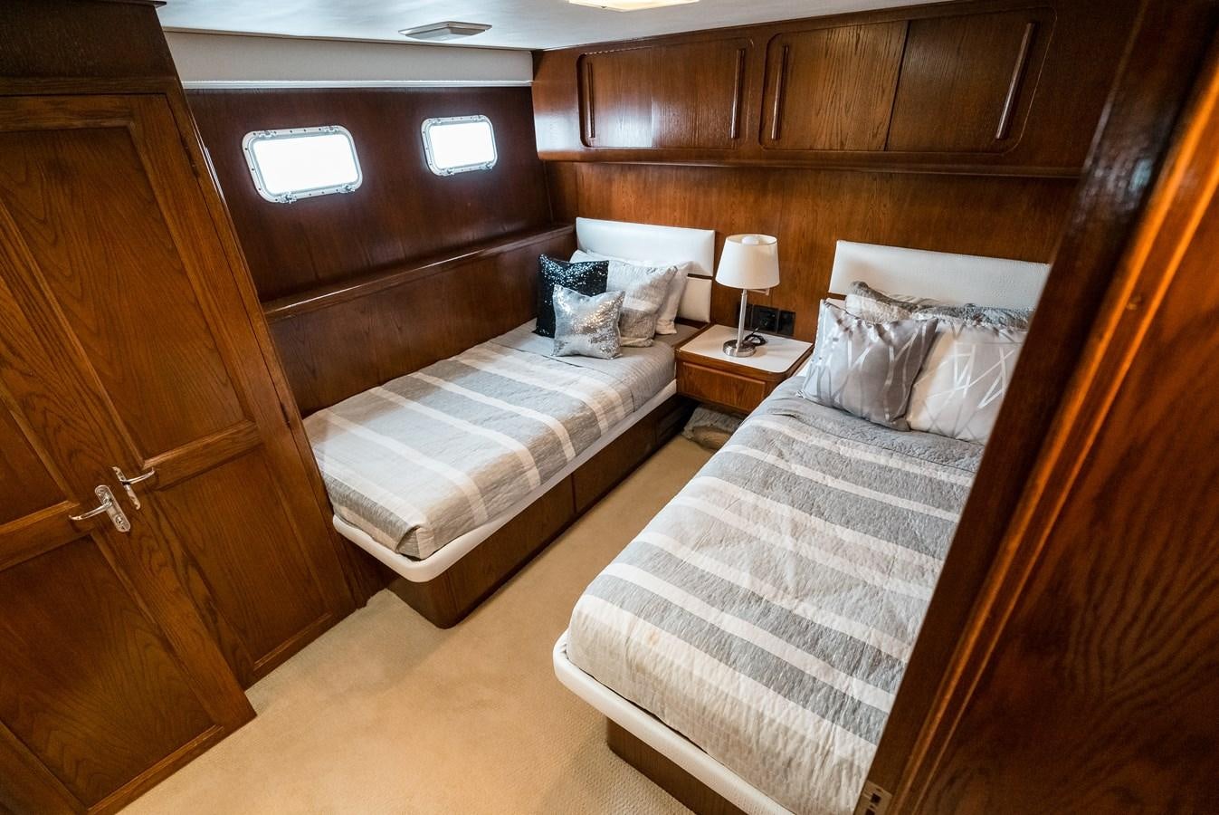 a room with a bed and a night stand aboard HIGH IMPACT Yacht for Sale