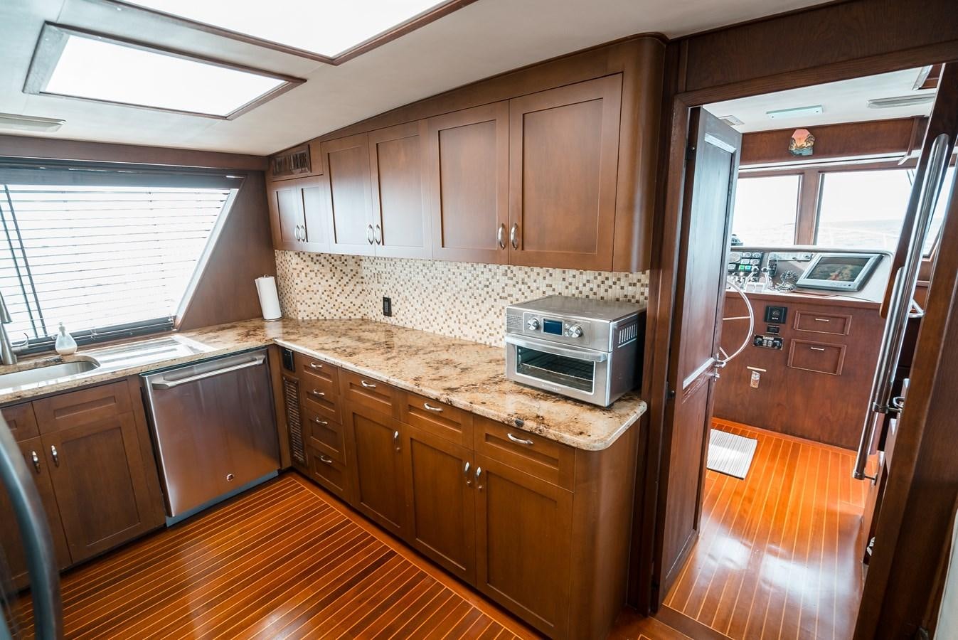 a kitchen with wooden cabinets aboard HIGH IMPACT Yacht for Sale