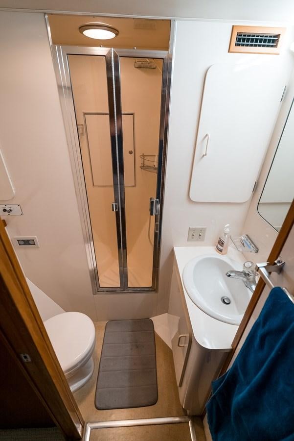 a bathroom with a shower sink and toilet aboard HIGH IMPACT Yacht for Sale